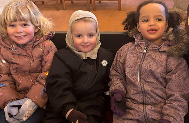Tre børnehavepiger lytter til Lucia-gudstjenesten i Blistrup Kirke