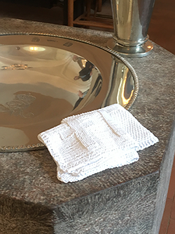 Dåbsklud med fade og kande. Dåbskludene er strikke af nørkledamerne